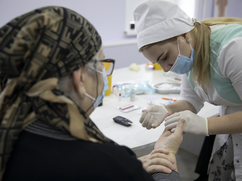 caption: A woman undergoes antibody testing before an injection of the Russian COVID-19 vaccine known as Sputnik V at an outpatient clinic in Grozny earlier this week.