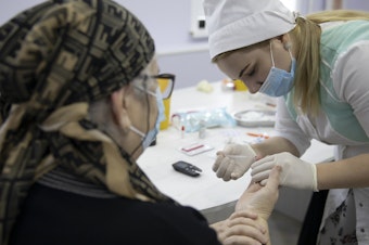 caption: A woman undergoes antibody testing before an injection of the Russian COVID-19 vaccine known as Sputnik V at an outpatient clinic in Grozny earlier this week.