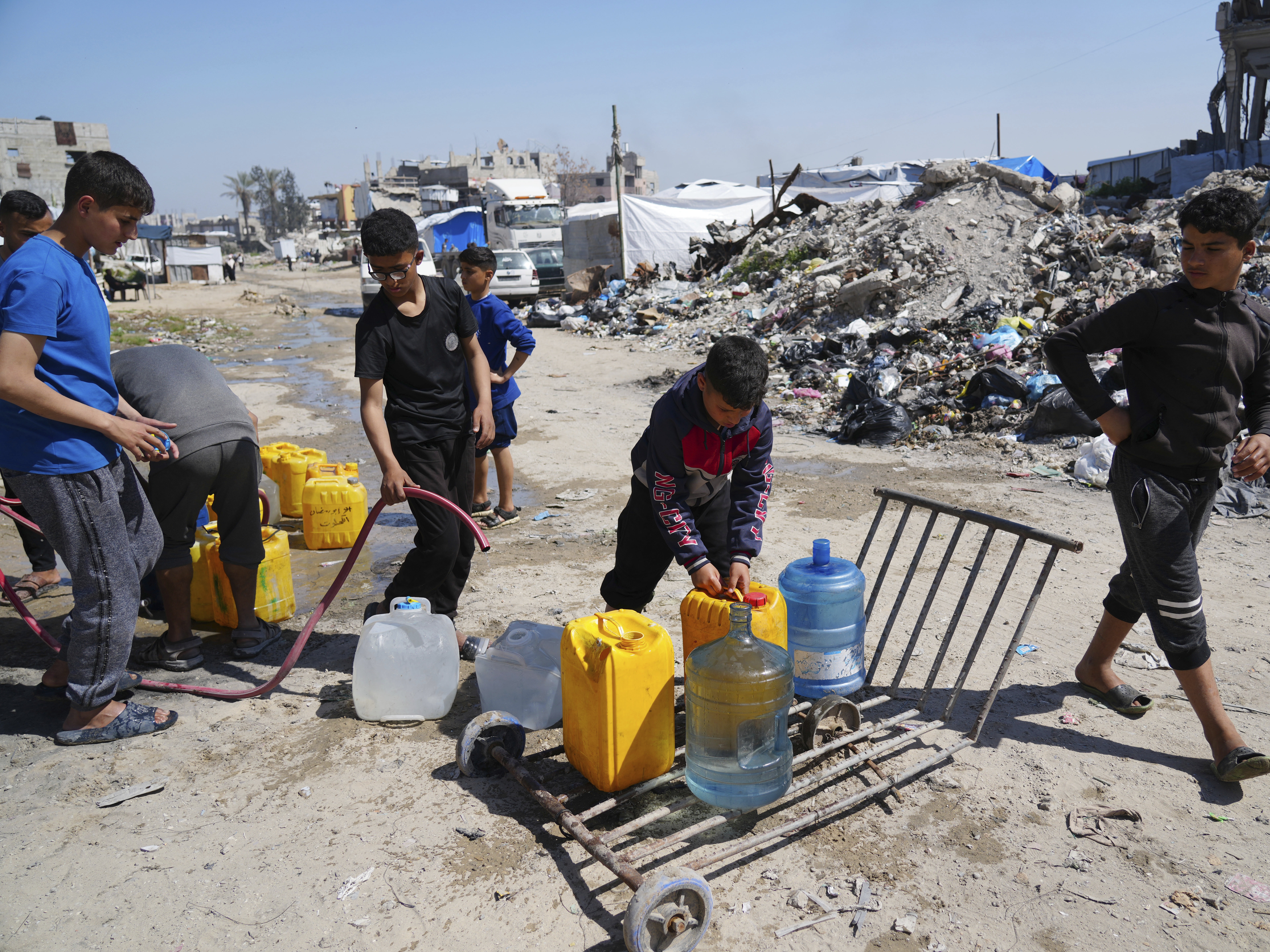 caption: Young Palestinians fill cans with water in Jabaliya, northern Gaza Strip, on Sunday. Arab negotiators are trying to broker a ceasefire deal that would avert a return to fighting in Gaza and begin serious negotiations toward a formal end of the war, since the breakdown of the Israel-Hamas ceasefire deal at the beginning of the month.