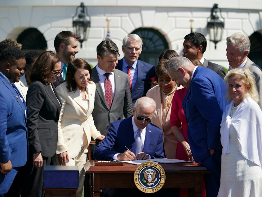 caption: President Biden signed the CHIPS and Science Act on the South Lawn of the White House on August 9. The legislation is aimed at boosting the domestic production of semiconductors.