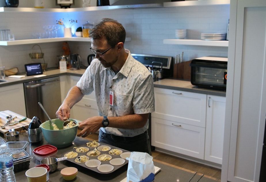 caption: Primed host Joshua McNichols bakes muffins in Amazon's smart home laboratory test kitchen.