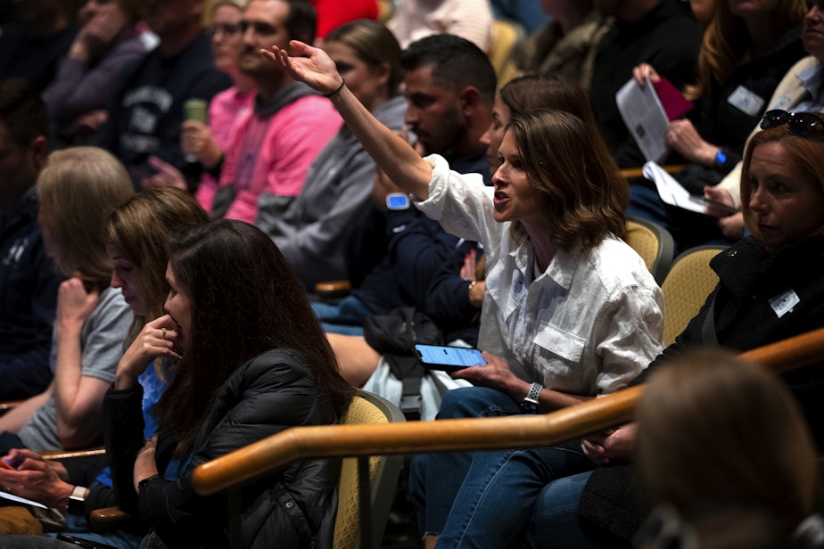 caption: Alexandra Laks addresses Seattle Public Schools officials during a school closures meeting where questions were not allowed on Tuesday, May 28, 2024, at Roosevelt High School in Seattle.  