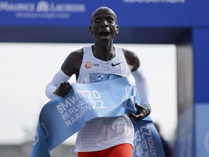 caption: Kenya's Eliud Kipchoge crosses the line to win the Berlin Marathon in Berlin on Sunday.