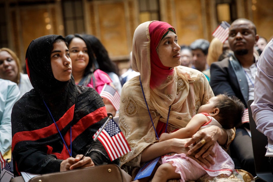 caption: Mosammat Rasheda Akter, originally from Bangladesh, holds her 7 month-old daughter Fahmida as she waits to officially become a U.S. Citizen during a naturalization ceremony at the New York Public Library, July 3, 2018 in New York City. (Drew Angerer/Getty Images)