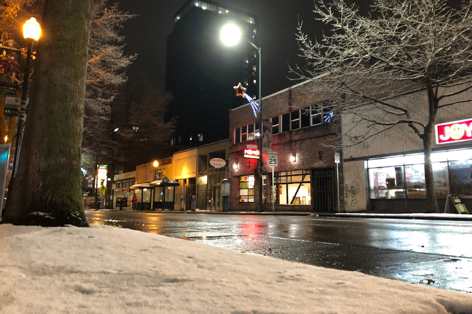 caption: Snow blankets the sidewalks of Seattle's University District, but doesn't stick long on University Avenue, Jan. 13, 2020. 