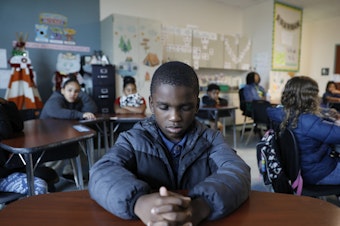 caption: A student named Royce closes his eyes during a mindfulness session in class at Patricia J. Sullivan Partnership School in Tampa, Fla. Students say the daily lessons help them cope with their feelings.