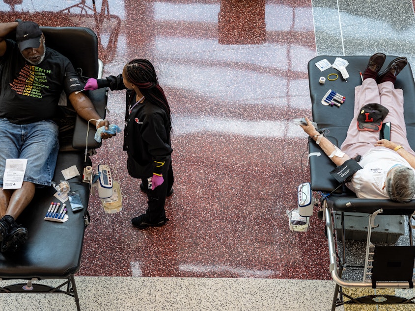 caption: A phlebotomist tends to a blood donor during the Starts, Stripes, and Pints blood drive event in Louisville, Ky., in July. Rising numbers of organ transplants, trauma cases, and elective surgeries postponed by the COVID-19 pandemic have caused an increase in the need for blood products.