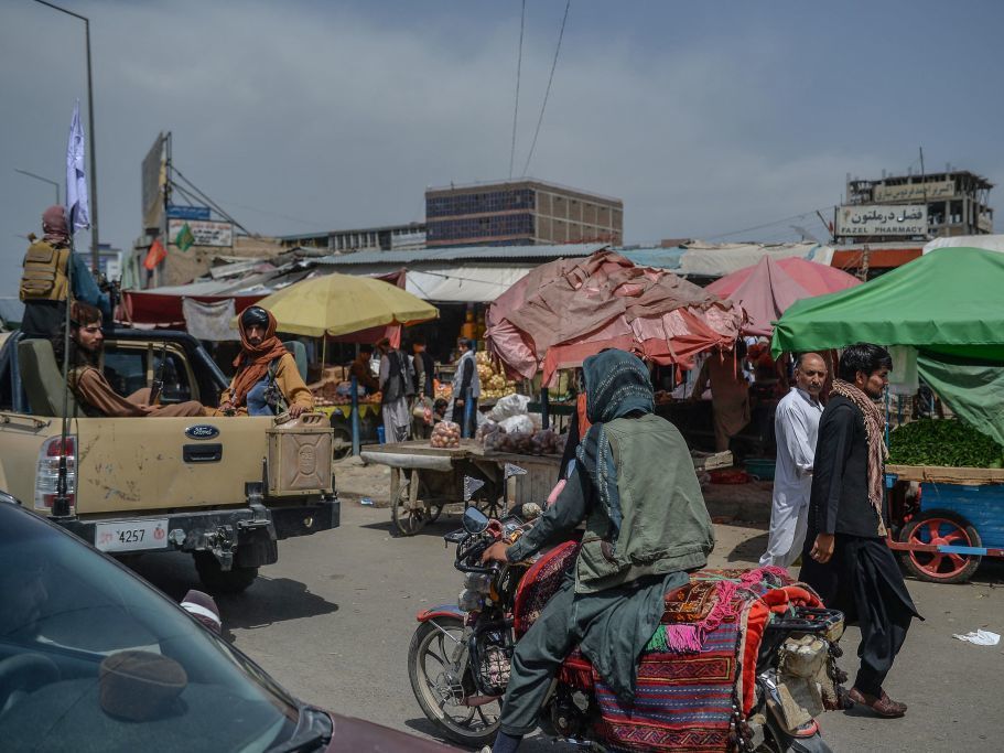 caption: Taliban fighters on a pickup truck move around a market area Tuesday in Kabul, Afghanistan's capital.