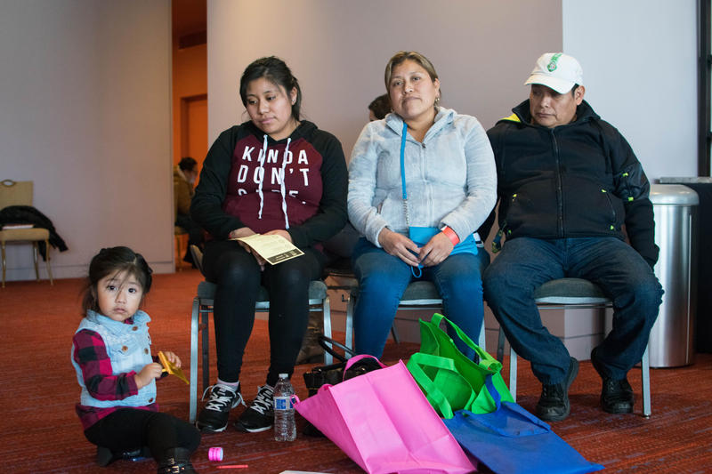 caption: A family waits to speak with an immigration attorney at a free legal clinic hosted by the City of Seattle.
