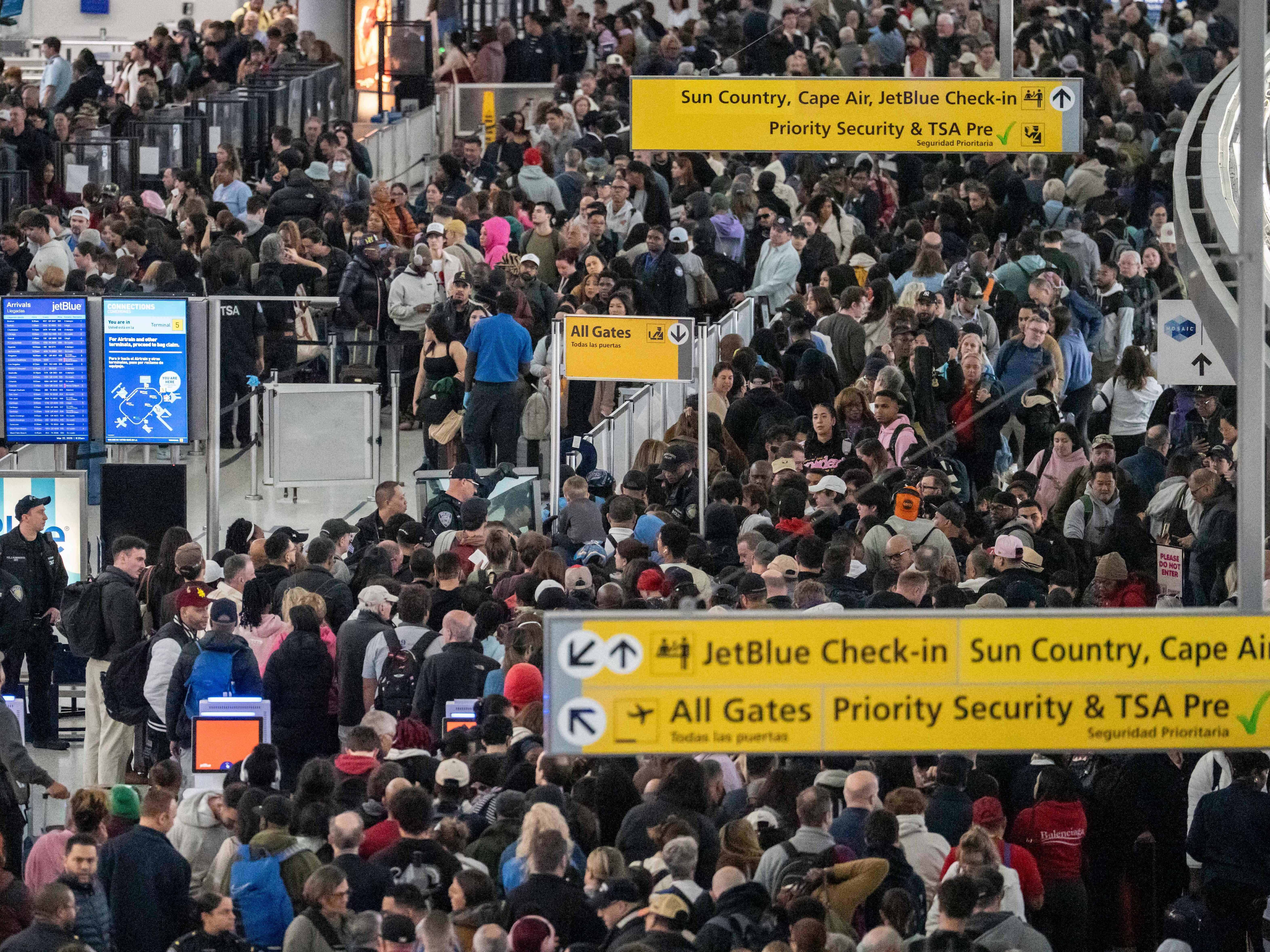caption: People wait in a TSA line at the John F. Kennedy International Airport on Sunday in New York City.