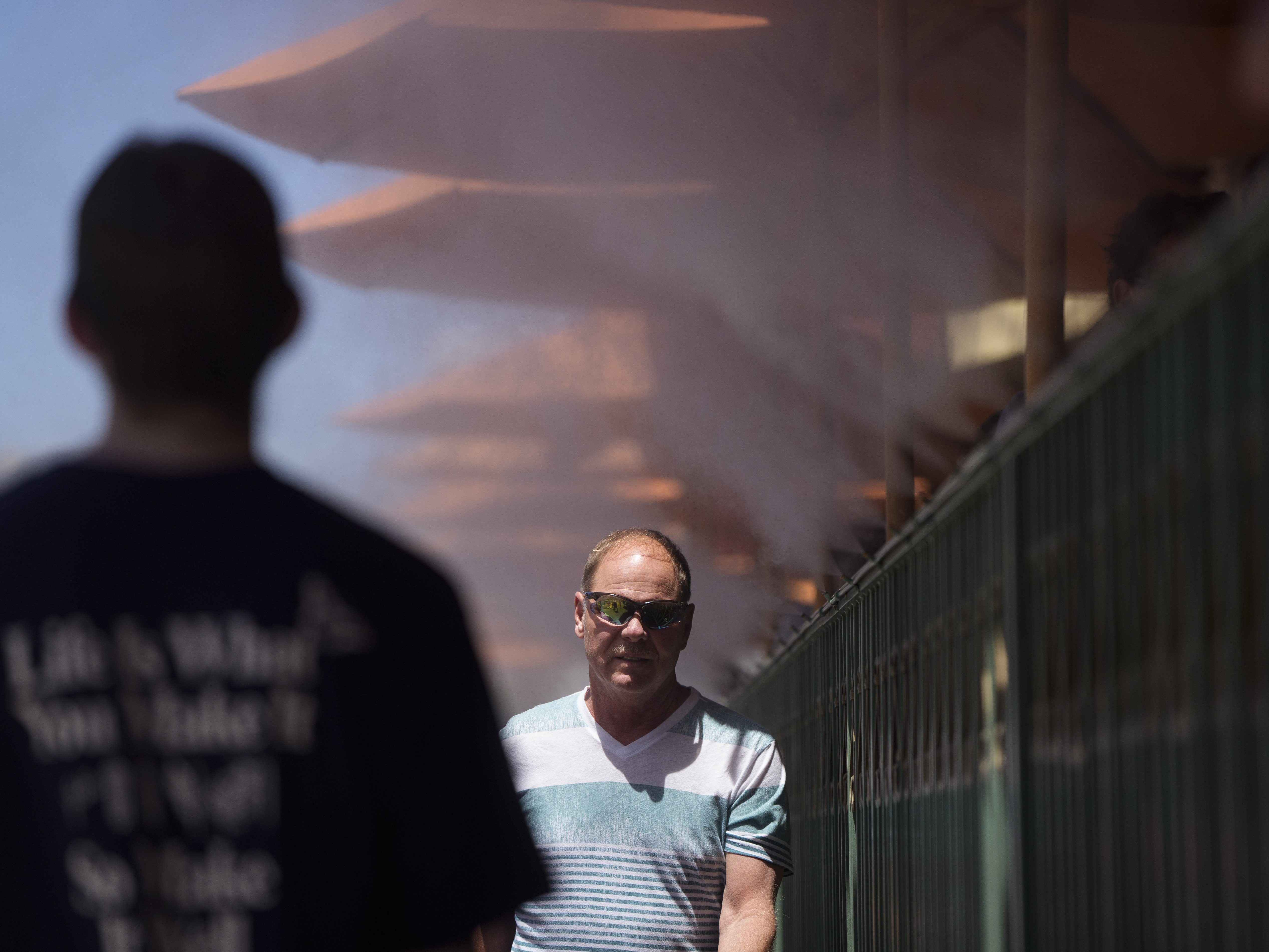 caption: People walk through cooling misters on June 4, 2024 in Las Vegas. Tens of millions of people from California to Texas are experiencing intense heat. New data shows that the amount of planet-warming carbon dioxide in the atmosphere has hit a new record.