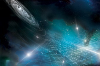 caption: This artist's impression shows a pair of supermassive black holes circling each other and sending out gravitational waves, which affect the bright, shining pulsars.