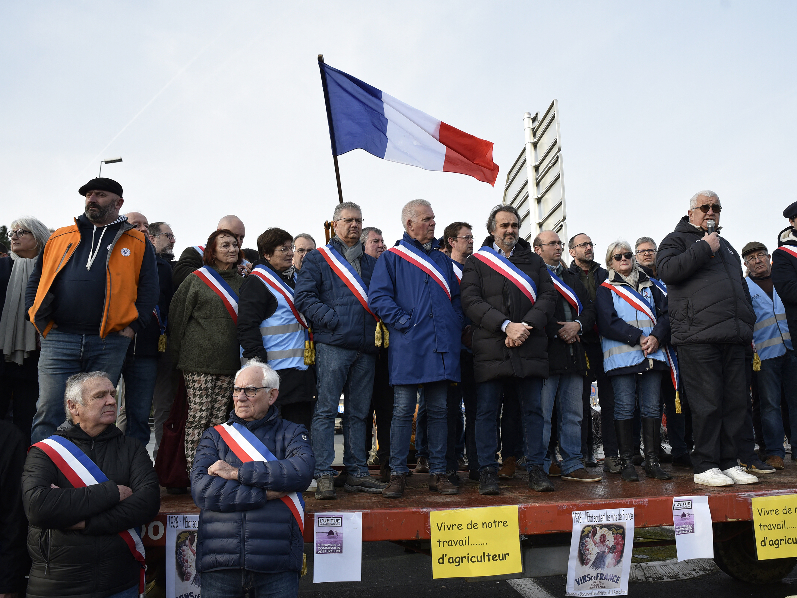 caption: Jerome Guillem, mayor of Langon, and other French mayors, farmers and wine growers block highway entrances to the town of Langon, toward the A62 highway in Gironde, France, on Jan. 29.