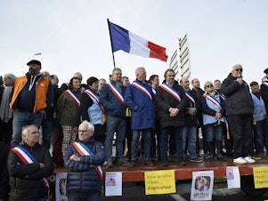 caption: Jerome Guillem, mayor of Langon, and other French mayors, farmers and wine growers block highway entrances to the town of Langon, toward the A62 highway in Gironde, France, on Jan. 29.