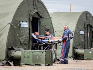 caption: A patient is transferred to a hospital after receiving medical care at an improvised military aid station set up to treat suspected cases of dengue fever in the administrative region of Ceilandia, on the outskirts of Brasilia, on February 6, 2024.
