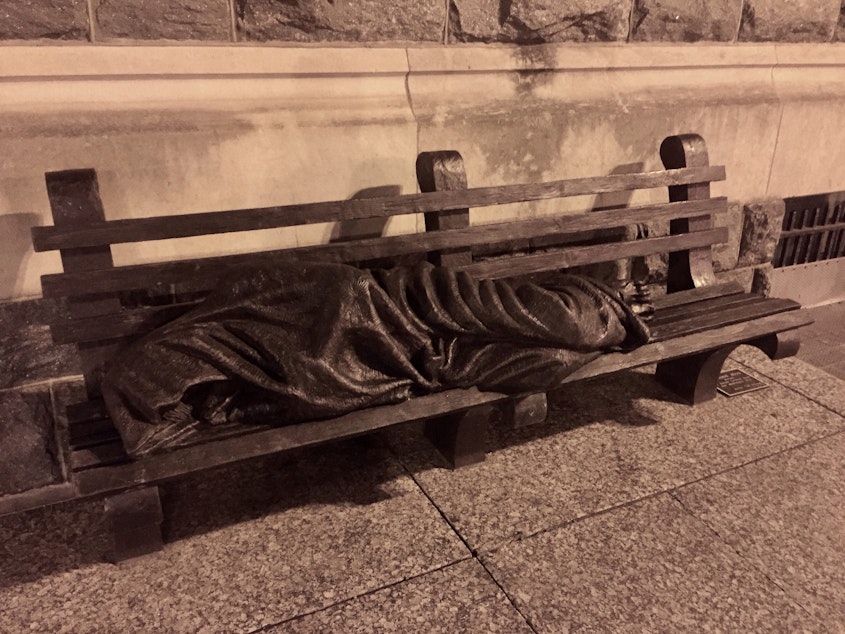 caption: This statue depicting Jesus as a homeless person has been replicated in cities around the world, including Seattle.