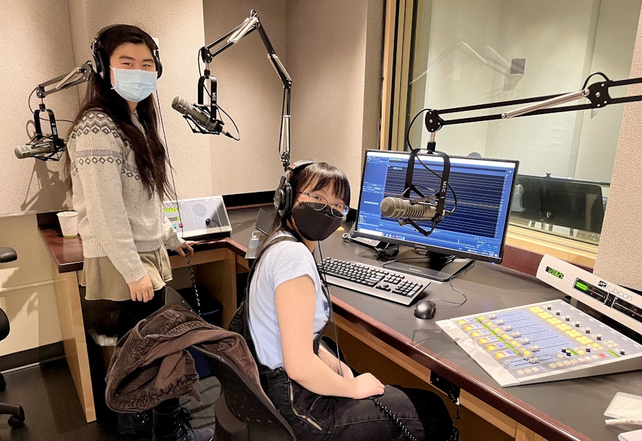 caption: Emily Chua (left) and Alayna Ly record narration in a KUOW studio on May 7, 2022 as part of the RadioActive Advanced Producers Workshop.
