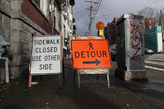 caption: Mark Adreon took KUOW on a walk through Capitol Hill to demonstrate how hard it is being blind and navigating the endless construction sites in the city. When he arrived at this spot, the placards through him off course.