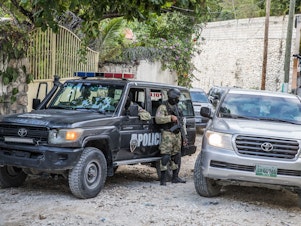 caption: Police stand guard outside the residence of the late Haitian President Jovenel Moïse in Port-au-Prince on July 15 in the wake of his assassination on July 7.