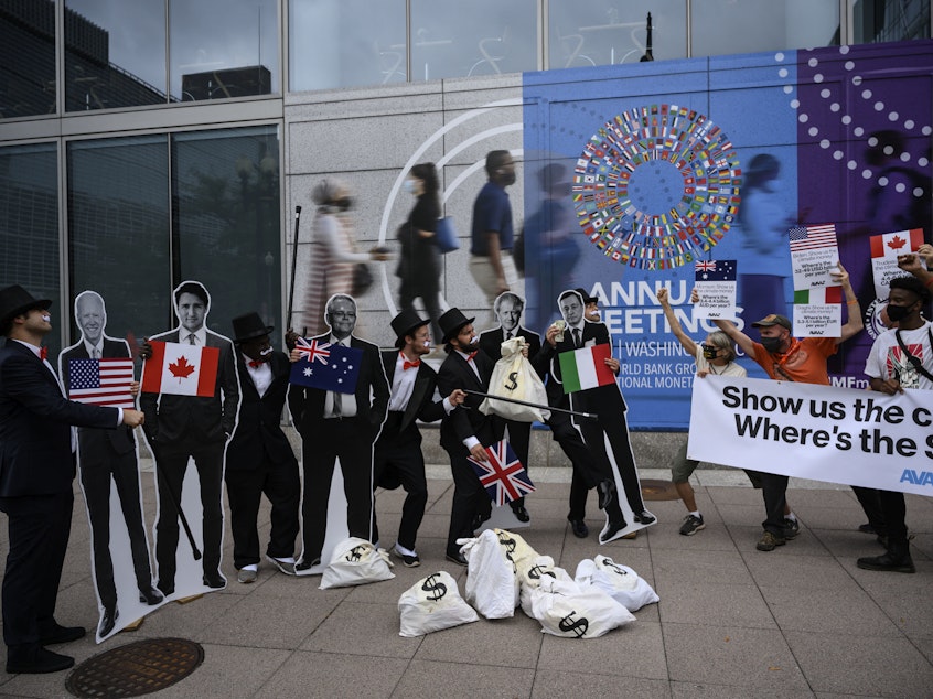 caption: Activists dressed as debt collectors hold cutouts of the leaders of the United States, Canada, Australia, the UK and Italy in front of the International Monetary Fund headquarters in Washington, D.C., last month to ask rich nations to keep their financial commitment to developing countries to tackle climate change.