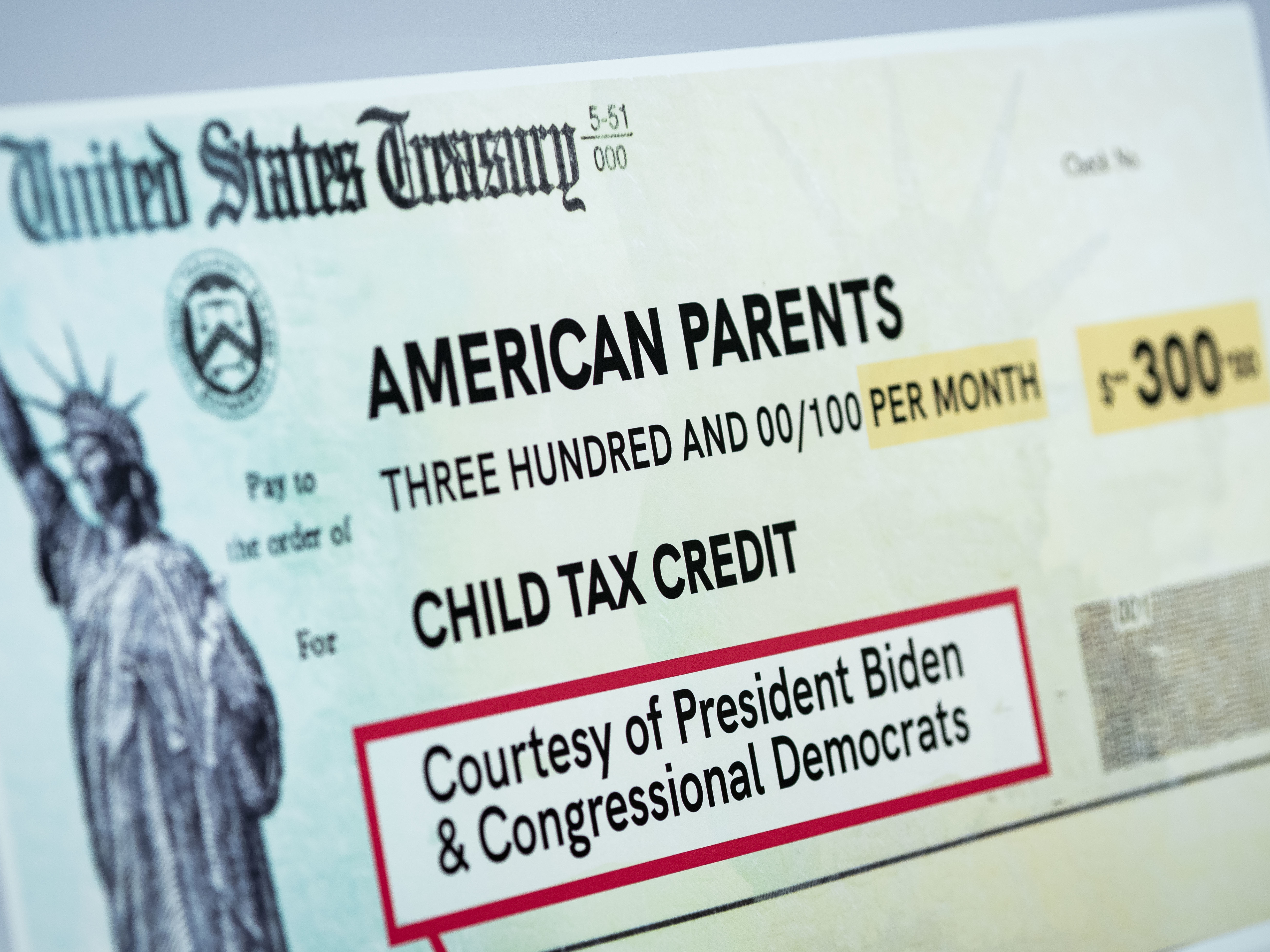 caption: A child tax credit poster is displayed during a news conference in Washington, D.C., on July 15. Early data shows that after the child tax credit payments went out this summer, the number of households with children who experience food insufficiency dropped.