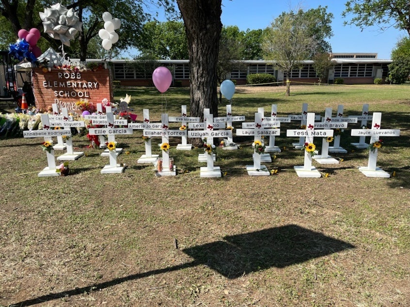 caption: A memorial to the students and faculty who died stands in front of Robb Elementary School in Uvalde, Texas. It's not clear who put the memorial up and authorities have not released the names of the deceased.