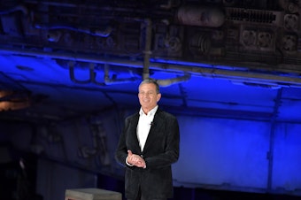 caption: Disney CEO Bob Iger speaks on stage at the Disneyland Resort in Anaheim, Calif., on May 29. Iger says Disney might stop filming in the state of Georgia should a new, restrictive abortion law take effect.