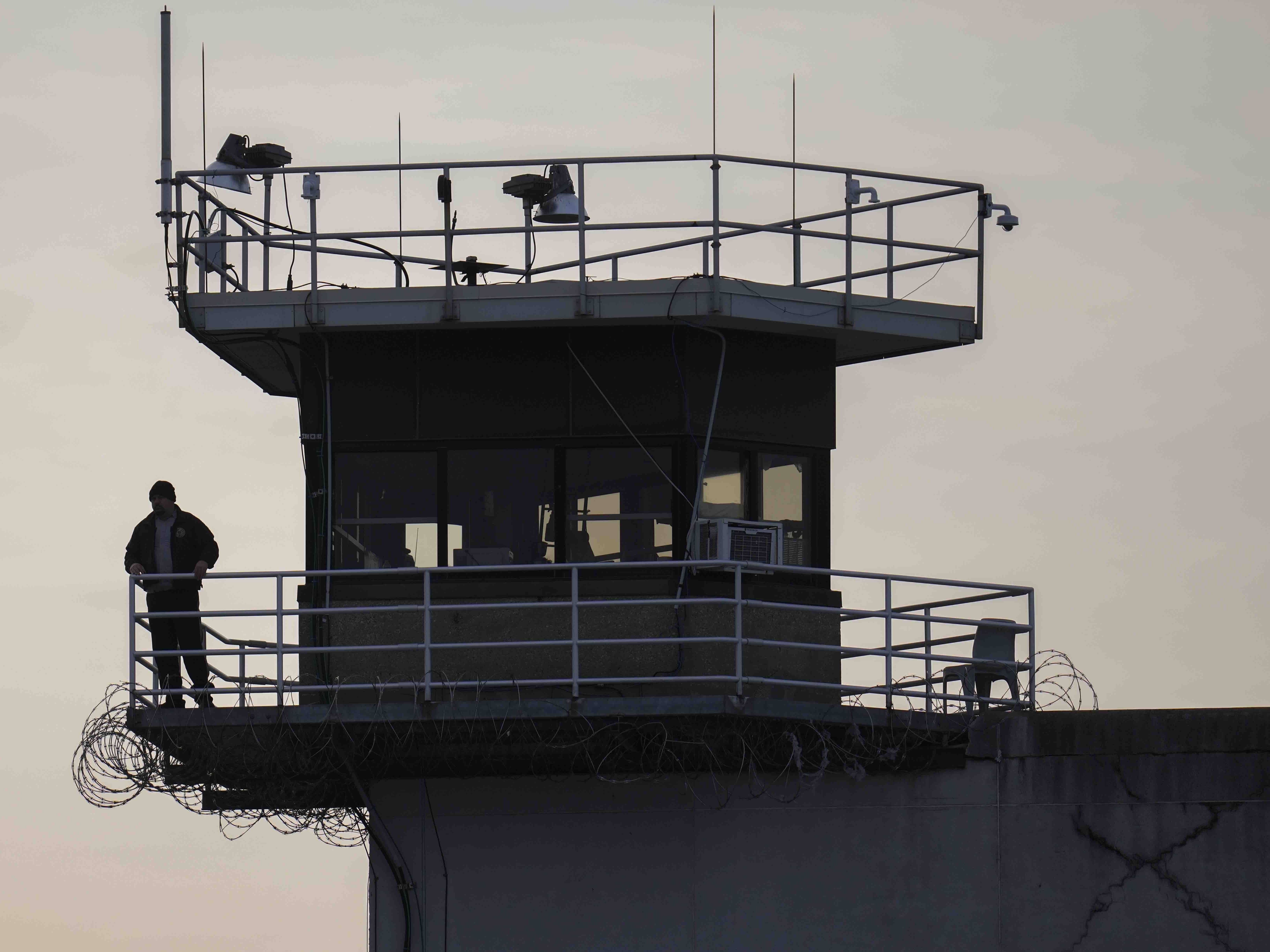caption: A guard stands in a tower at Indiana State Prison on Tuesday, Dec. 17, 2024, in Michigan City, Ind., where, barring last-minute court action or intervention by Gov. Eric Holcomb, Joseph Corcoran, 49, convicted in the 1997 killings of his brother and three other people, is scheduled to be put to death by lethal injection before sunrise on Wednesday.