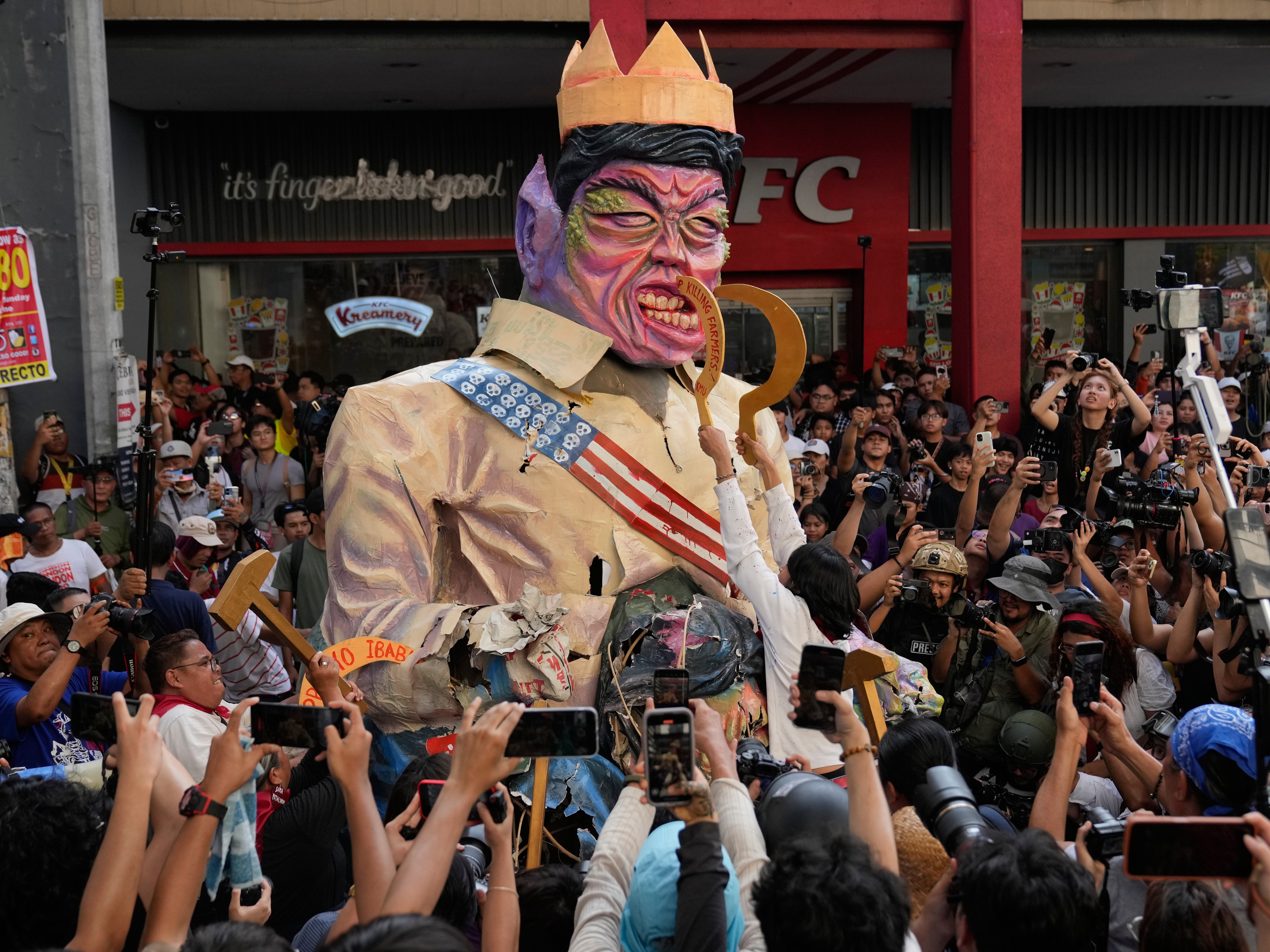 caption: Protesters destroy an effigy of Philippine President Ferdinand Marcos Jr. during an anti-corruption rally in Manila, Philippines on, Sunday, Nov. 30, 2025.