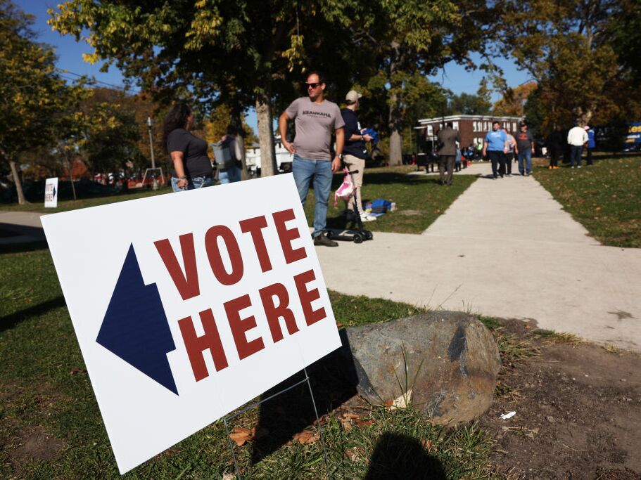 caption: Residents vote in early voting at a park building in Detroit on Oct. 19. Detroit is the first Michigan community to have early voting. Both Vice President Harris and former President Donald Trump have been campaigning in the key battleground state of Michigan.