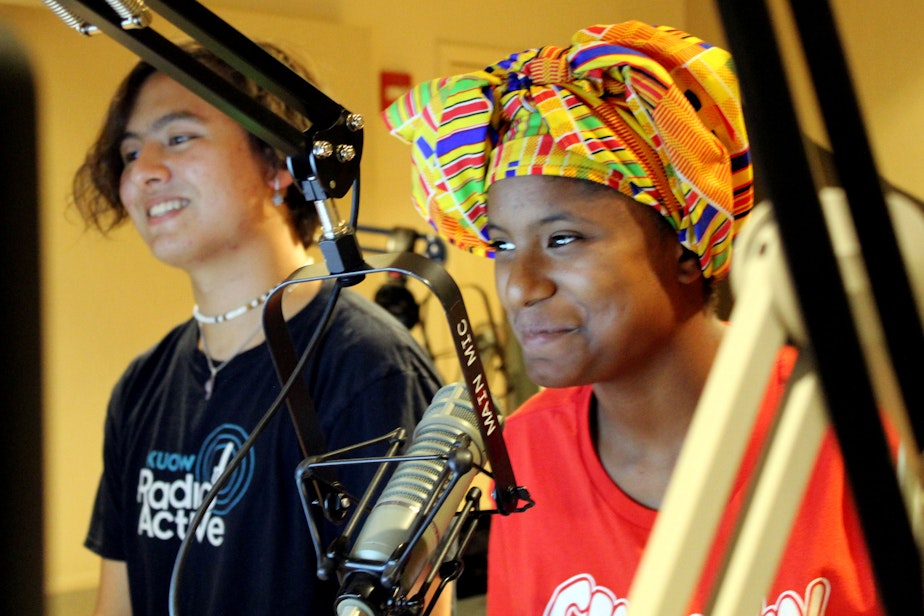 caption: Hayden Andersen (left) and Taniya Guster record in a KUOW studio.