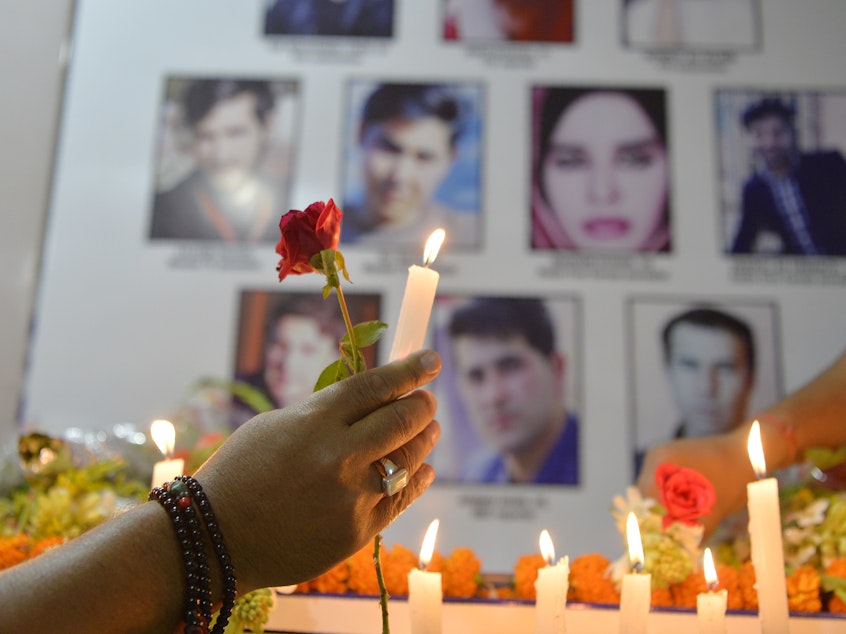 caption: Journalists light candles in Siliguri, India, on May 3, during a vigil for Afghan journalists who were killed in a targeted suicide bombing in Kabul on April 30.