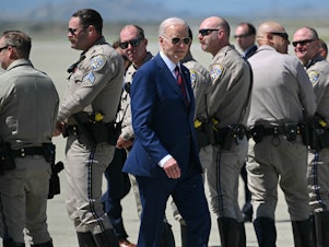 caption: President Biden makes his way to Air Force One after posing with highway patrol troopers in Mountain View, Calif. on May 10.