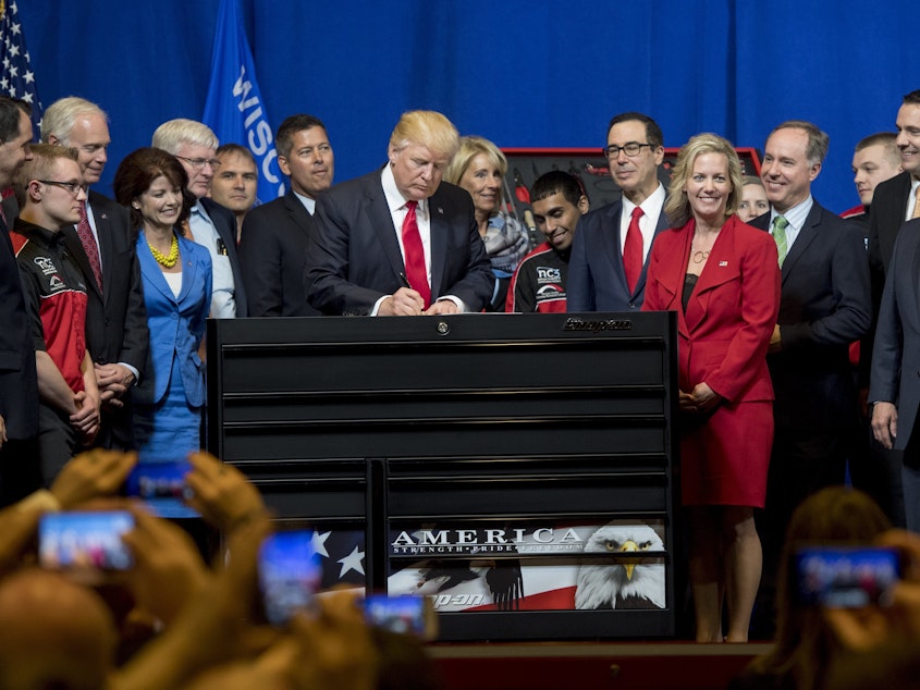 caption: President Trump signs a "Buy American, Hire American" executive order at Snap-On Tools in Kenosha, Wis., back in 2017.