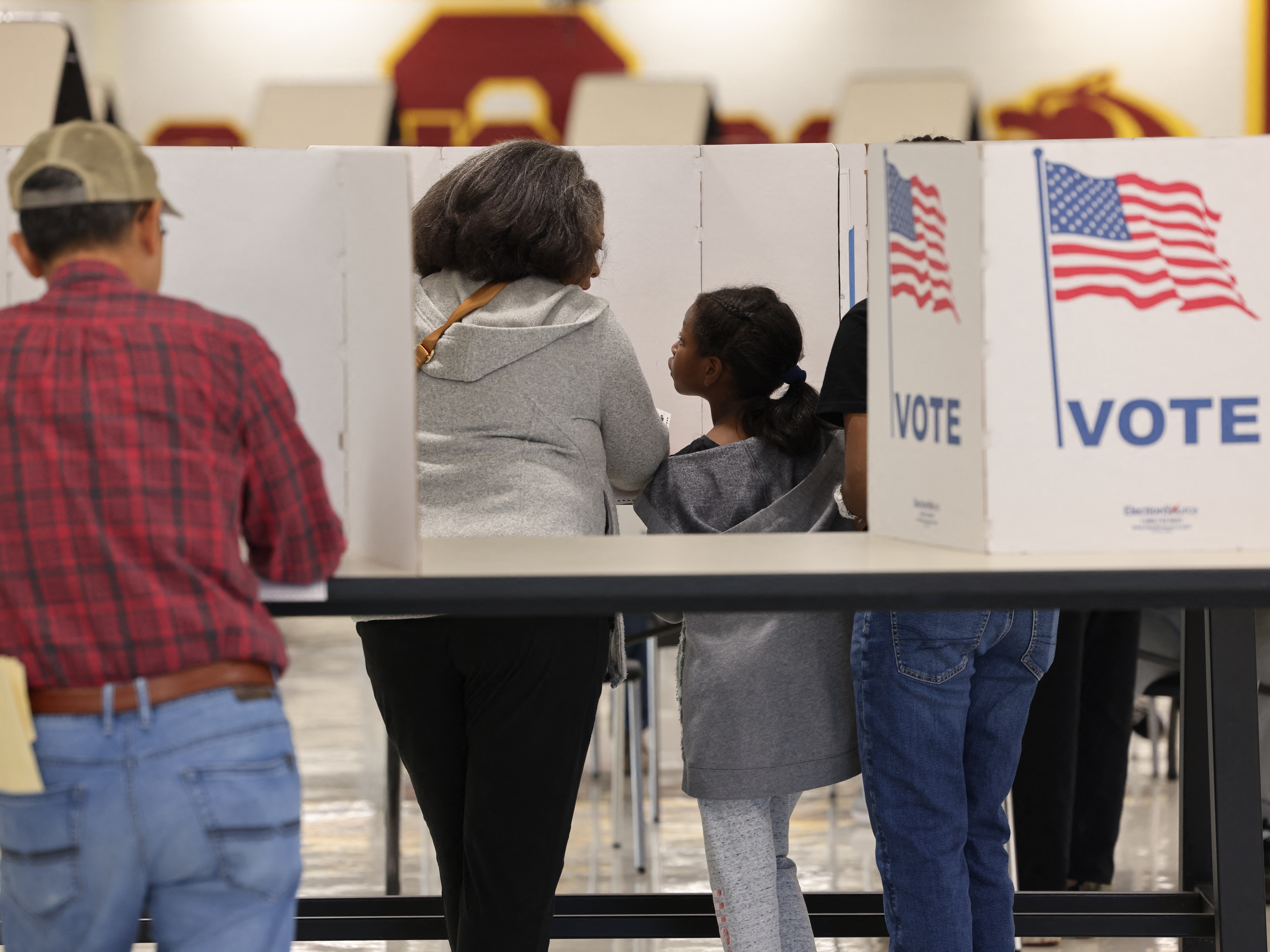 caption: Voters gather at polling station in Oakton, Va., on Nov. 5. Parents are grappling with how to talk to their children about the election.