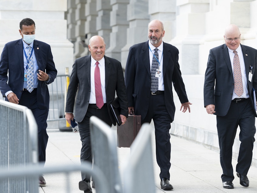 caption: Postmaster General Louis DeJoy, second from left, leaves the U.S. Capitol after meeting Wednesday with Democratic leaders.