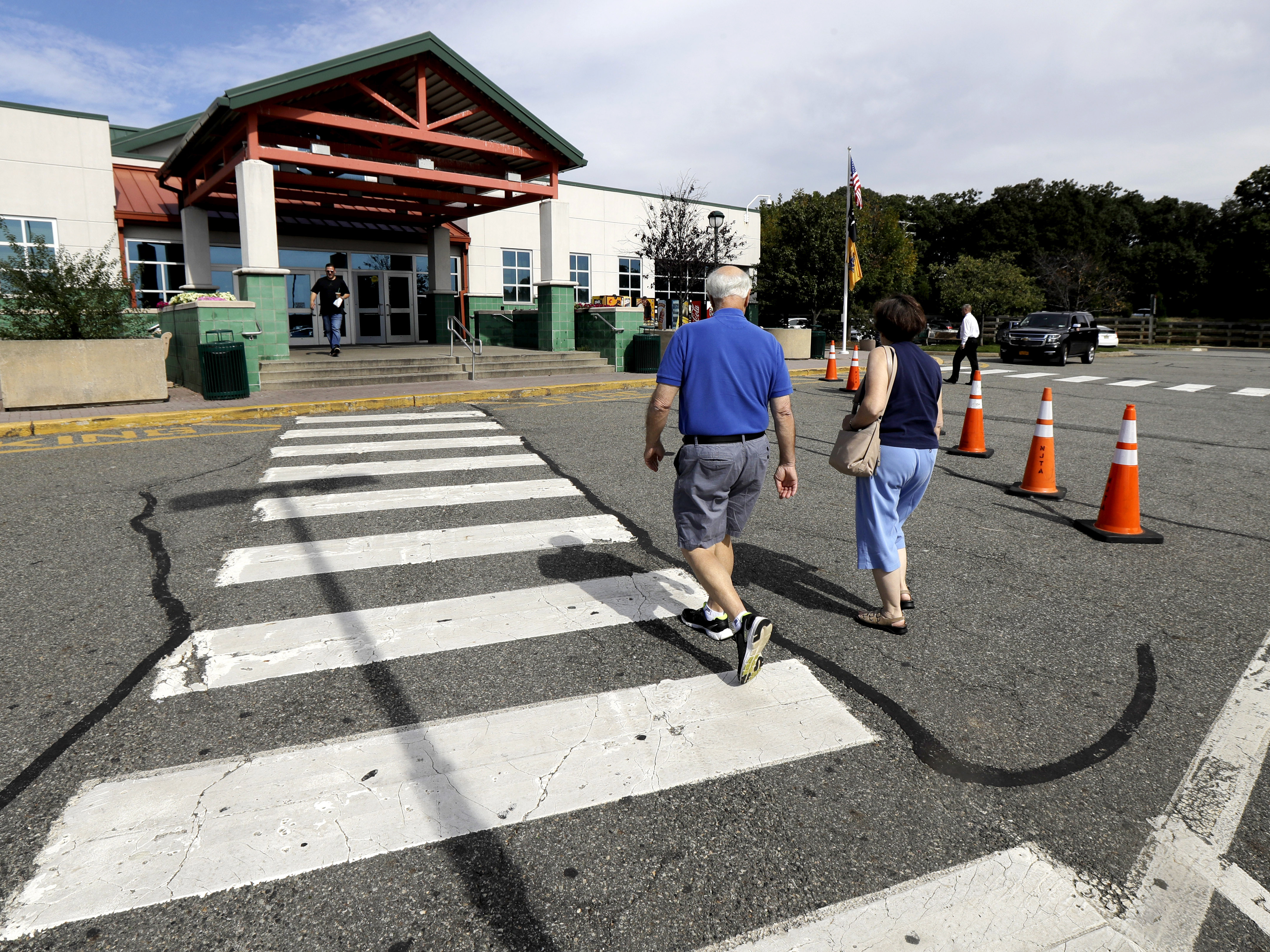 caption: People head into the service building at the Cheesequake Rest Area in South Amboy, N.J.