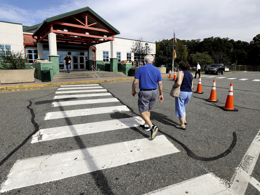 caption: People head into the service building at the Cheesequake Rest Area in South Amboy, N.J.