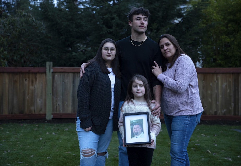 caption: Christy Maricle, right, stands for a portrait with her three children, Cadence, 20, Kaitlyn 13, Caileigh, 7, holding a portrait of their father, Kurt, on Thursday, December 9, 2022,at their home in Puyallup. Kurt Mrsny died of Covid in September of 2021. 