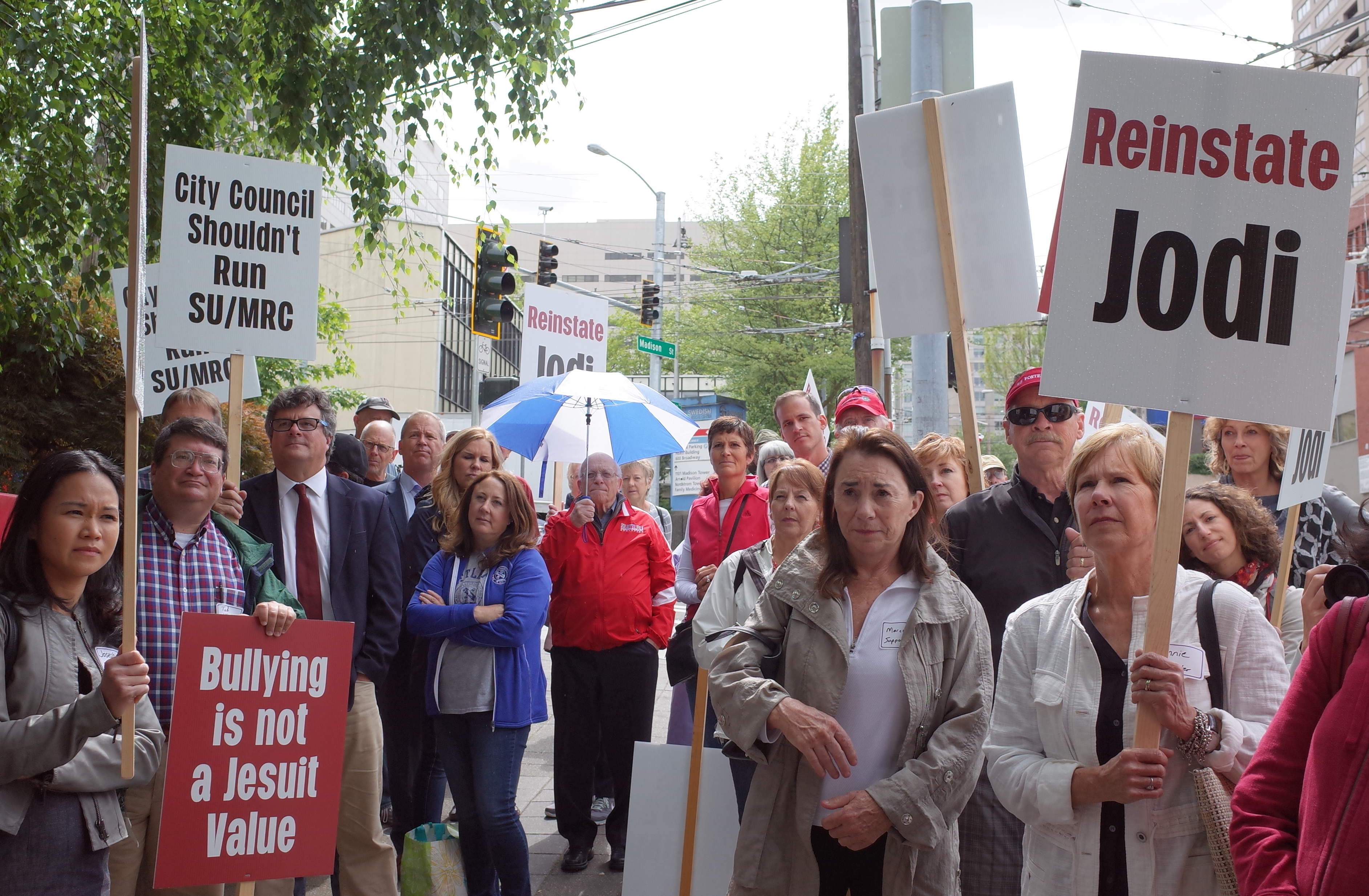 caption: About 40 people gathered outside Seattle Universtiy to support embattled dean Jodi Kelly, who has been placed on administrative leave. This is a hostile takeover type of situation, said Beth Derrig, who held a sign that said, We want the truth.
