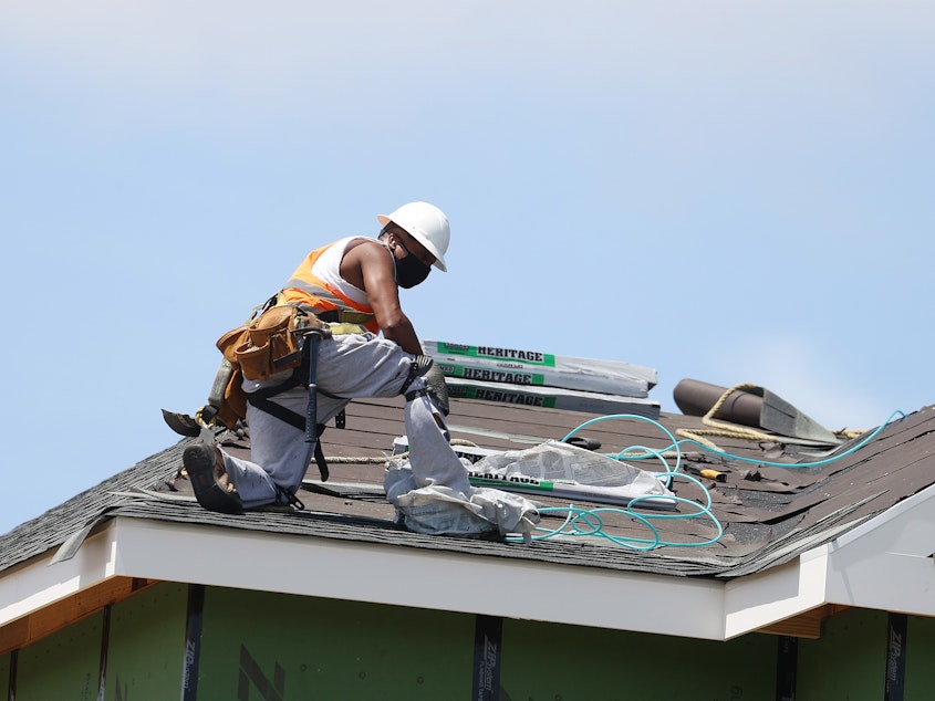 caption: A construction worker roofs an apartment complex in Uniondale, N.Y., on May 27. U.S. employers added fewer jobs last month even as the unemployment rate fell to 8.4%.