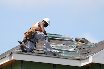 caption: A construction worker roofs an apartment complex in Uniondale, N.Y., on May 27. U.S. employers added fewer jobs last month even as the unemployment rate fell to 8.4%.