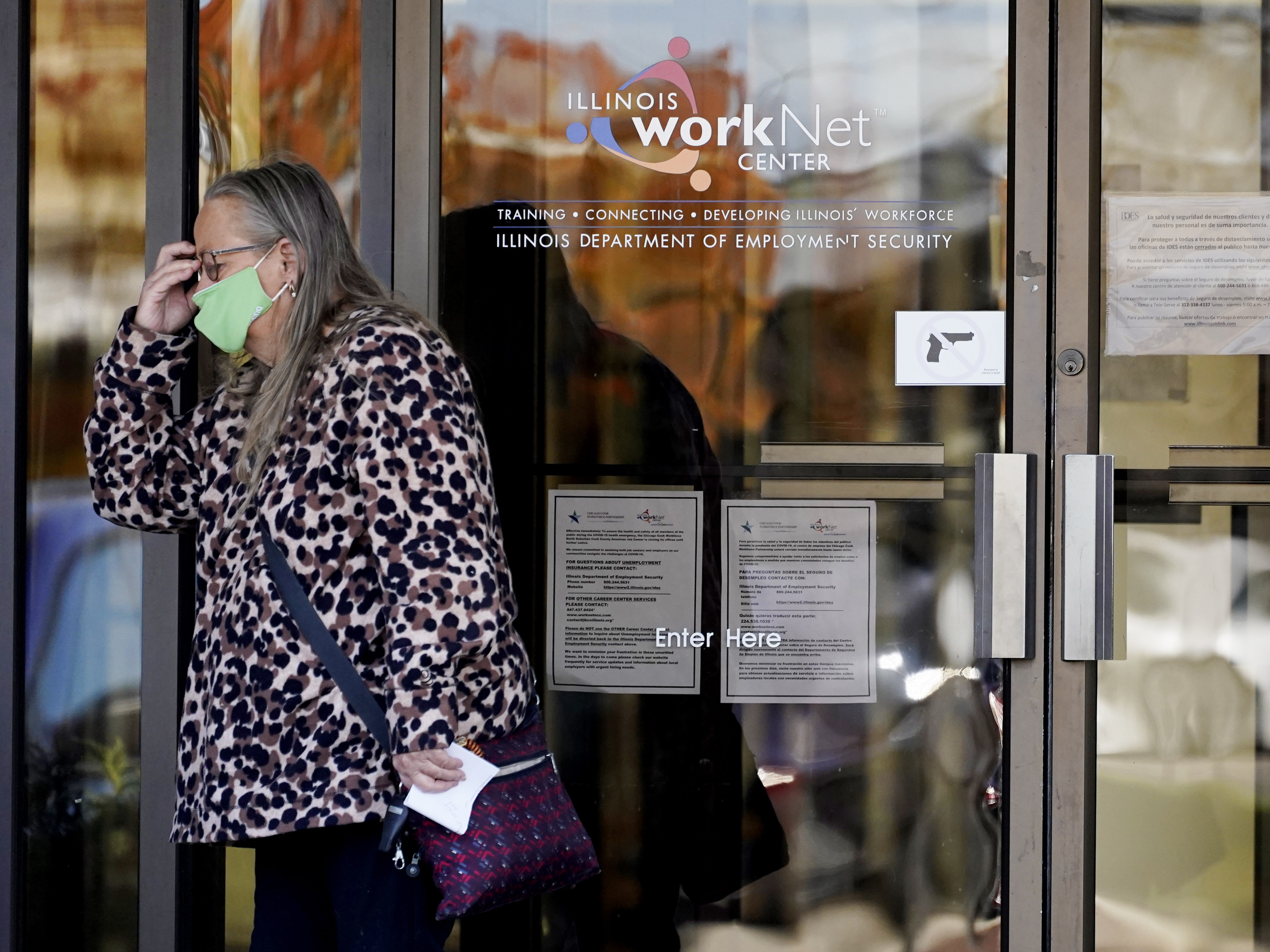 caption: A woman reacts as she leaves the Illinois Department of Employment Security WorkNet center in Arlington Heights, Ill., on Thursday. The state has reported a spike of nearly 10,000 new coronavirus cases. It also reports biggest spike in unemployment claims of all states due to the pandemic.