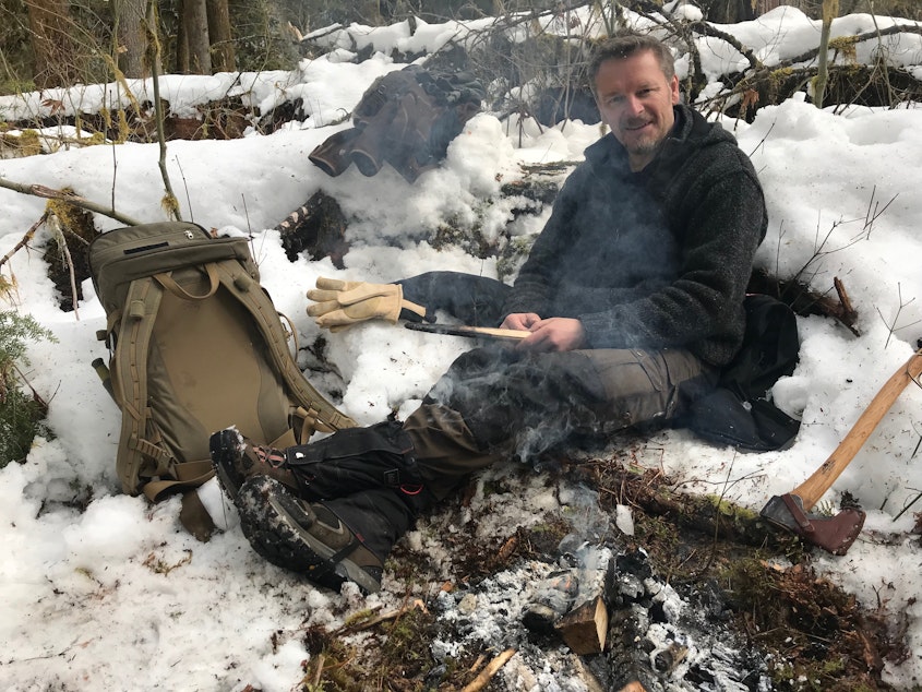 caption: Chris building a fire while out recording THE WILD on location.