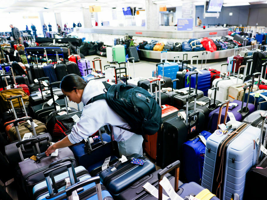 caption: Pristine Floyde searches for a friend's suitcase in a baggage holding area for Southwest Airlines at Denver International Airport in December 2022.