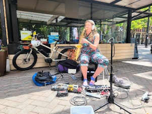 caption: Kate Olson plays an alto saxophone in Occidental Park on Friday, July 7, 2023.