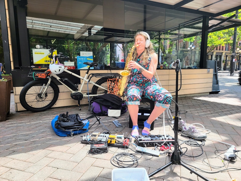 caption: Kate Olson plays an alto saxophone in Occidental Park on Friday, July 7, 2023.