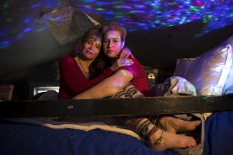 caption: Rene Reynoso, left, and Cheyenne Reynoso, right, embrace on the bunk bed in their tiny home on Wednesday, March 21, 2018, at the Licton Springs Tiny House Village on Aurora Avenue North in Seattle. 
