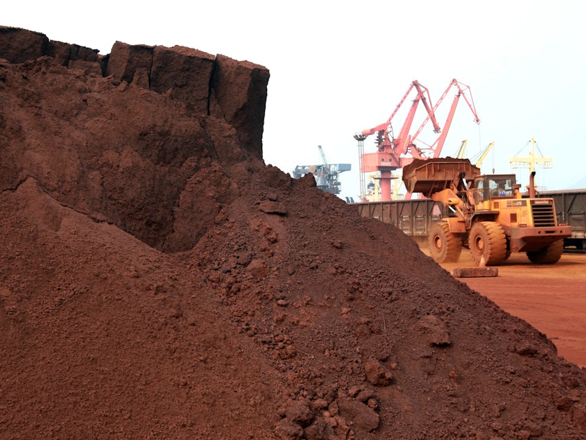 caption: A worker in China shifts soil containing rare earth minerals intended for export in 2010.