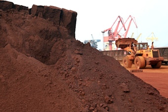 caption: A worker in China shifts soil containing rare earth minerals intended for export in 2010.